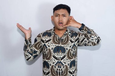 Rahatsız suratlı, batik giyen genç Endonezyalı adam bana jest diyor.