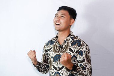 Batik giyen genç Endonezyalı erkekler başarıyı kutluyor