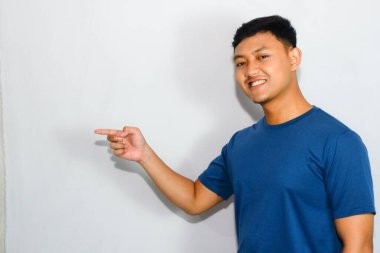 Dost canlısı genç Endonezyalı adam mavi tişört giyiyor.