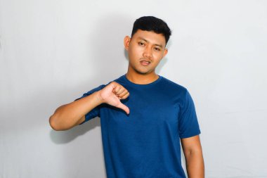 Asyalı adam mavi gömlekli, baş parmağını kaldırıyor.