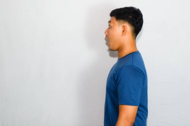 Dost canlısı genç Endonezyalı adam mavi tişört giyiyor.