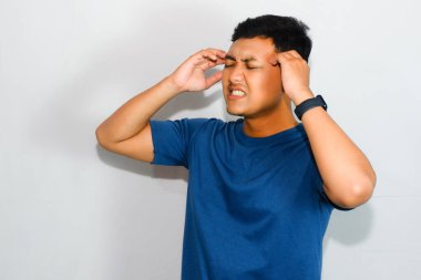 Baş ağrısı olan Asyalı genç bir adam.