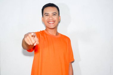 Dost canlısı, turuncu tişörtlü Asyalı adam öne bakıyor.