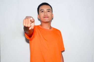 Dost canlısı, turuncu tişörtlü Asyalı adam öne bakıyor.