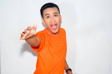 Dost canlısı, turuncu tişört giyen Asyalı adam yardım istiyor.