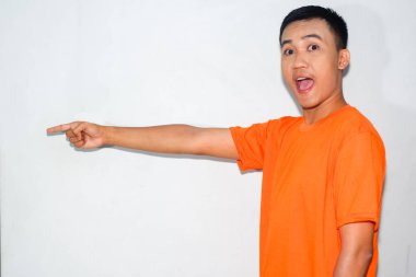 Dost canlısı, turuncu tişörtlü Asyalı adam yan tarafı işaret ediyor.