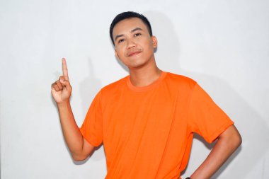 Dost canlısı, turuncu tişört giyen Asyalı adam yukarı doğru hareketler yapıyor.