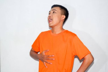 Dost canlısı, turuncu tişört giyen Asyalı adam yemekten sonra doymuş hissediyor.