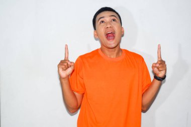 Dost canlısı, turuncu tişörtlü, yüzünde iki parmağıyla işaret eden Asyalı adam.