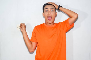 Dost canlısı, turuncu tişörtlü, şaşırmış bir Asyalı.