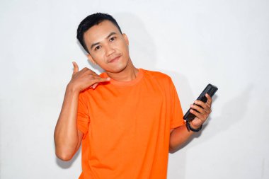 Dost canlısı, turuncu tişörtlü, elinde akıllı bir telefon tutan ve 