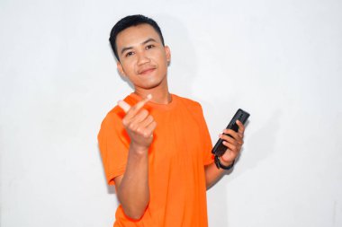 Dost canlısı, turuncu tişörtlü, elinde akıllı bir telefon tutan ve sarangheo hareketi yapan Asyalı bir adam. Aşk kavramı, iletişim, ya da sevgiyi ifade etmek.