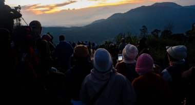 Gün doğumunu izleyen bir grup turistin silueti. Seyahat, macera, doğa değerlendirmesi ve grup keşifleri kavramı