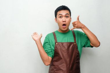 Yeşil gömlekli ve kahverengi önlüklü genç adam bana şaşırmış bir ifadeyle jest yapıyor. Acil iletişim, beklenmedik çağrı ya da iletişim kavramı