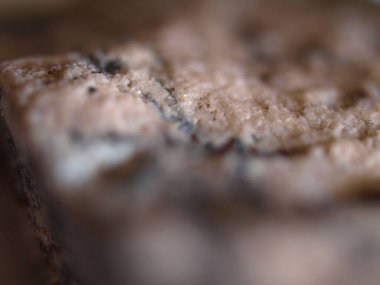 Doğal granit taşın yakın çekim dokusu, granüler detayları ışık ve koyu mineral parçacıkları karışımıyla gösteriyor.. 