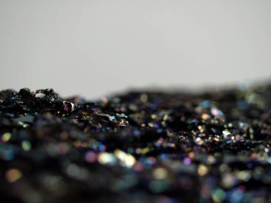 Makro karborundum şat, parlak gökkuşağı renkli kristallerini sergiliyor keskin, açısal formasyonları var. Metalik yüzey, canlı yansımalarla, kozmik bir manzarayı çağrıştırıyor..