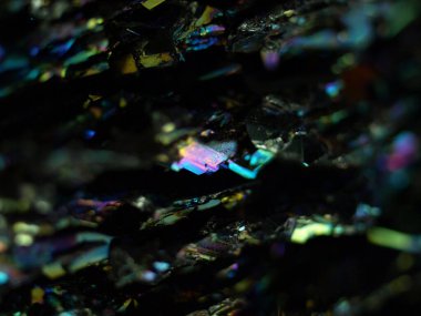 Makro karborundum şat, parlak gökkuşağı renkli kristallerini sergiliyor keskin, açısal formasyonları var. Metalik yüzey, canlı yansımalarla, kozmik bir manzarayı çağrıştırıyor..