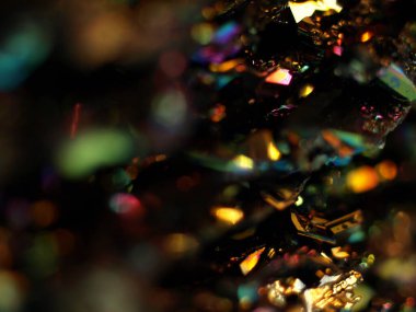 Makro karborundum şat, parlak gökkuşağı renkli kristallerini sergiliyor keskin, açısal formasyonları var. Metalik yüzey, canlı yansımalarla, kozmik bir manzarayı çağrıştırıyor..