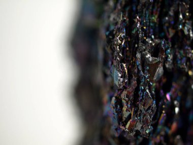 Makro karborundum şat, parlak gökkuşağı renkli kristallerini sergiliyor keskin, açısal formasyonları var. Metalik yüzey, canlı yansımalarla, kozmik bir manzarayı çağrıştırıyor..