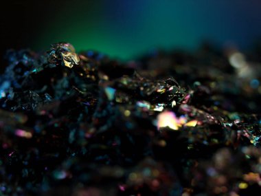 Makro karborundum şat, parlak gökkuşağı renkli kristallerini sergiliyor keskin, açısal formasyonları var. Metalik yüzey, canlı yansımalarla, kozmik bir manzarayı çağrıştırıyor..