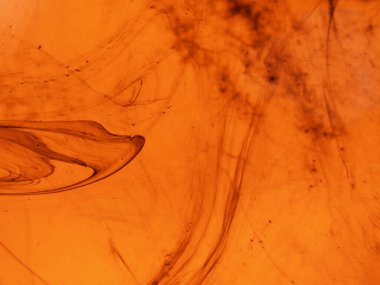 Karmaşık siyah çizgileri ve mineral desenlere benzeyen girdapları olan kehribar renkli mermer dokusu.. 