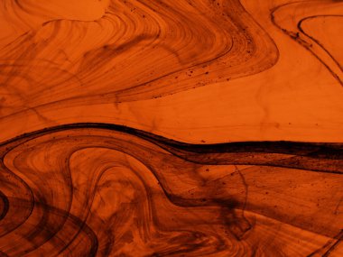 Karmaşık siyah çizgileri ve mineral desenlere benzeyen girdapları olan kehribar renkli mermer dokusu.. 