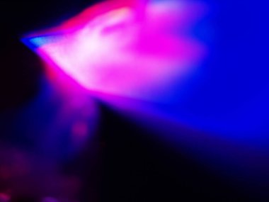 Canlı, üst üste binen renklerin soyut makro fotoğrafı koyu bir zemin üzerinde yumuşak ve ışıltılı bir etki yaratıyor. Bu renkli spektrum belirli bir hareket ve derinlik duygusunu yakalar..