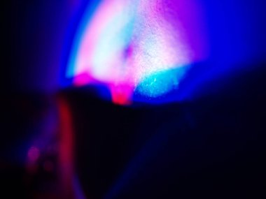 Canlı, üst üste binen renklerin soyut makro fotoğrafı koyu bir zemin üzerinde yumuşak ve ışıltılı bir etki yaratıyor. Bu renkli spektrum belirli bir hareket ve derinlik duygusunu yakalar..