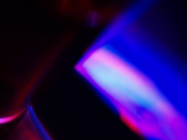 Canlı, üst üste binen renklerin soyut makro fotoğrafı koyu bir zemin üzerinde yumuşak ve ışıltılı bir etki yaratıyor. Bu renkli spektrum belirli bir hareket ve derinlik duygusunu yakalar..