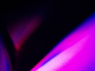 Canlı, üst üste binen renklerin soyut makro fotoğrafı koyu bir zemin üzerinde yumuşak ve ışıltılı bir etki yaratıyor. Bu renkli spektrum belirli bir hareket ve derinlik duygusunu yakalar..