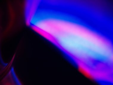 Canlı, üst üste binen renklerin soyut makro fotoğrafı koyu bir zemin üzerinde yumuşak ve ışıltılı bir etki yaratıyor. Bu renkli spektrum belirli bir hareket ve derinlik duygusunu yakalar..