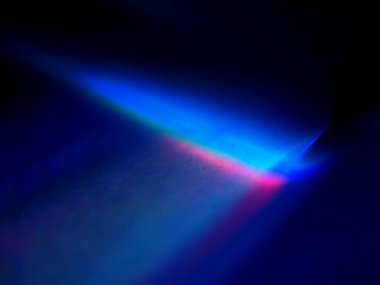 Canlı, üst üste binen renklerin soyut makro fotoğrafı koyu bir zemin üzerinde yumuşak ve ışıltılı bir etki yaratıyor. Bu renkli spektrum belirli bir hareket ve derinlik duygusunu yakalar..