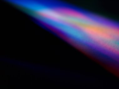 Canlı, üst üste binen renklerin soyut makro fotoğrafı koyu bir zemin üzerinde yumuşak ve ışıltılı bir etki yaratıyor. Bu renkli spektrum belirli bir hareket ve derinlik duygusunu yakalar..