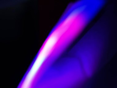 Canlı, üst üste binen renklerin soyut makro fotoğrafı koyu bir zemin üzerinde yumuşak ve ışıltılı bir etki yaratıyor. Bu renkli spektrum belirli bir hareket ve derinlik duygusunu yakalar..