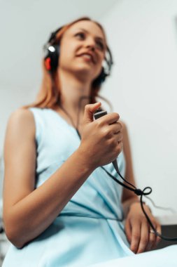 Audiologist doing impedance audiometry or diagnosis of hearing impairment. An beautiful redhead adult woman getting an auditory test at a hearing clinic.