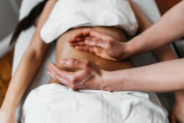 Güzel genç bir kadın aromaterapi ile profesyonel vücut masajı yaptırıyor..