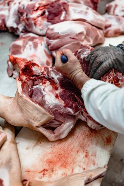 Tecrübeli işçiler çiğ gıda işleme tesisinde taze et kesiyorlar. Endüstriyel mezbaha işçisi işi. Gıda endüstrisi iş konsepti.