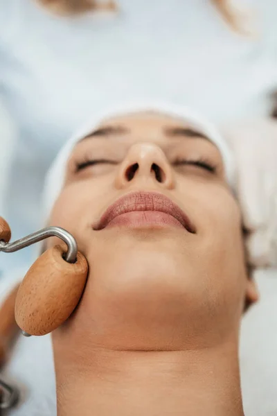 美しいブルネットは美容室で顔のマッサージ療法を取得します 専門的なスキンケア治療 — ストック写真