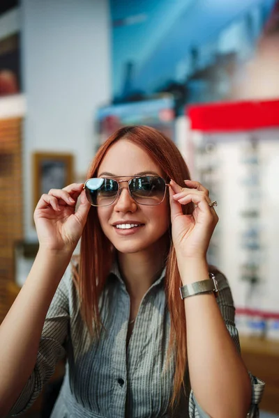 Beautiful Fashionable Redhead Woman Choosing Eyeglasses Frame Modern Optical Store — Foto de Stock