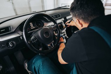 Profesyonel işçi araba temizleme iç ve ön panel, araba temizleme veya valelik konsepti. Seçici odaklanma. Ultra geniş açı..