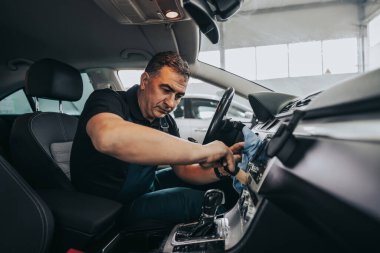 Profesyonel işçi araba temizleme iç ve ön panel, araba temizleme veya valelik konsepti. Seçici odaklanma. Ultra geniş açı..