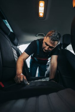 Profesyonel işçi araba temizleme iç ve ön panel, araba temizleme veya valelik konsepti. Seçici odaklanma. Ultra geniş açı..