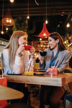 Alışveriş yaptıktan sonra kafeteryada ya da restoranda oturup mutlu mesut sohbet eden iki arkadaş.. 