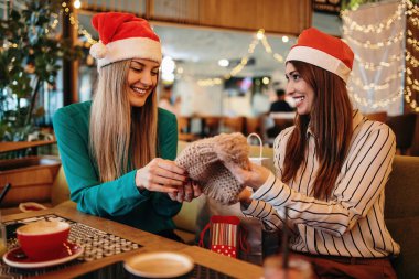 Noel Baba şapkalı iki arkadaş alışveriş yaptıktan sonra kafeteryada ya da restoranda oturup mutlu mesut sohbet ediyorlar. Ayrıca birbirlerine aldıkları kıyafetleri de gösteriyorlar..