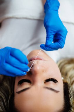 Professional permanent make up procedure. Tattoo lips makeup treatment in modern beauty salon.