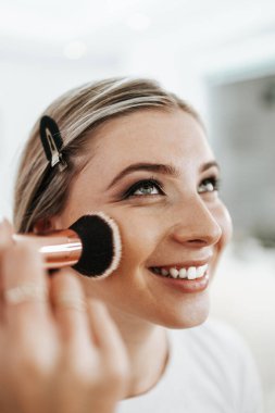 Makyaj süreci. Maket yüzünü fırçalayan profesyonel bir makyöz. Yüz temeli ve tonu cilde uygulanıyor. Güzellik salonundaki güzel sarışın kadının portresini yakından çek.. 