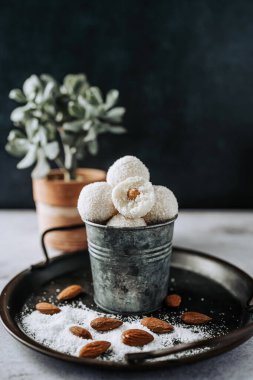 Beautiful and delicious homemade coconut flakes truffles with almonds and nuts in a retro grunge style.