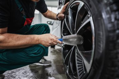 Araba tamirhanesinde mikrofiber bez ya da kumaşla lüks araba kenarı cilalayan profesyonel bir araba tamircisi. Ultra geniş açı..