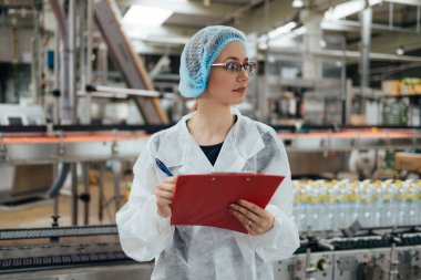 Tıbbi malzeme araştırma ve üretim fabrikasında çalışan ve sevkiyattan önce damıtılmış su kutularını kontrol eden koruyucu işçi. Denetim kalite denetimi. 