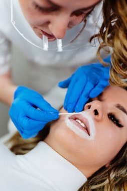 Professional permanent make up procedure. Tattoo lips makeup treatment in modern beauty salon.